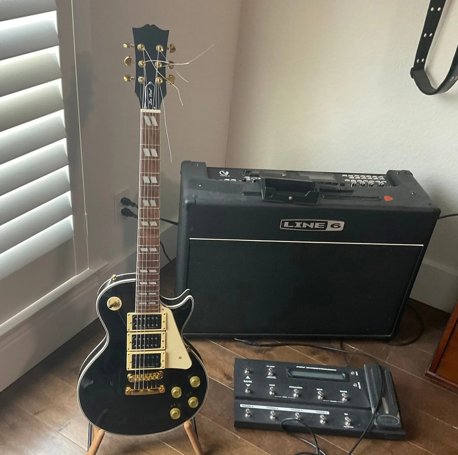 Completed black SJR guitar displayed with an amplifier