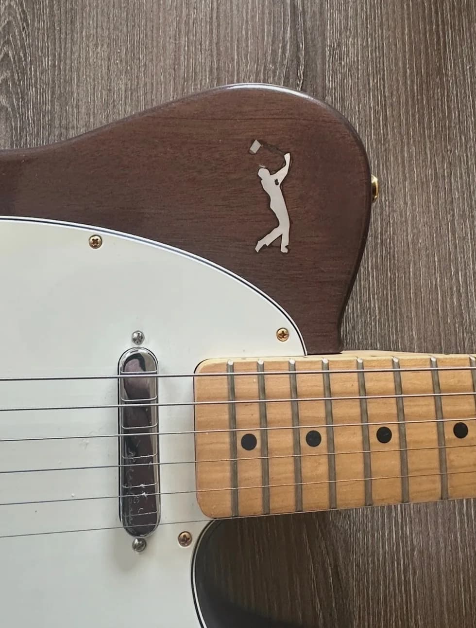 Personalized inlay detail on a brown custom guitar