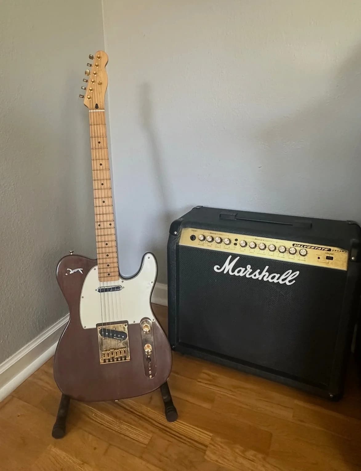 Completed brown personalized custom guitar displayed in a music room