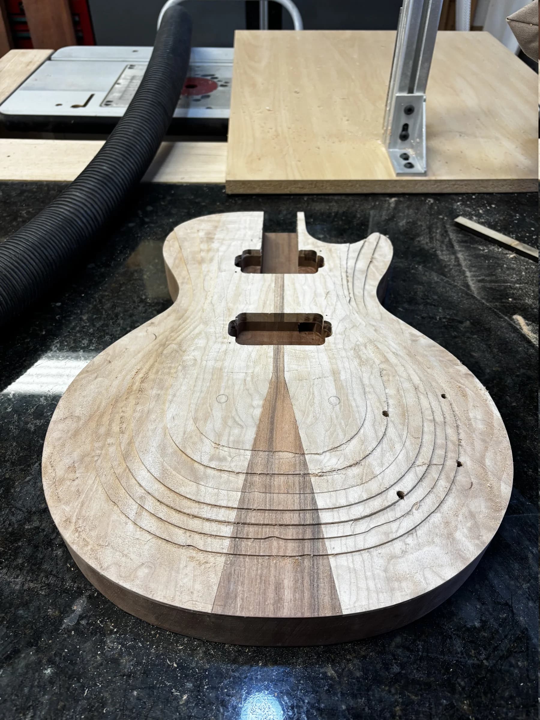 Figured single-cut guitar body with routed cavities and a tapered center stripe
